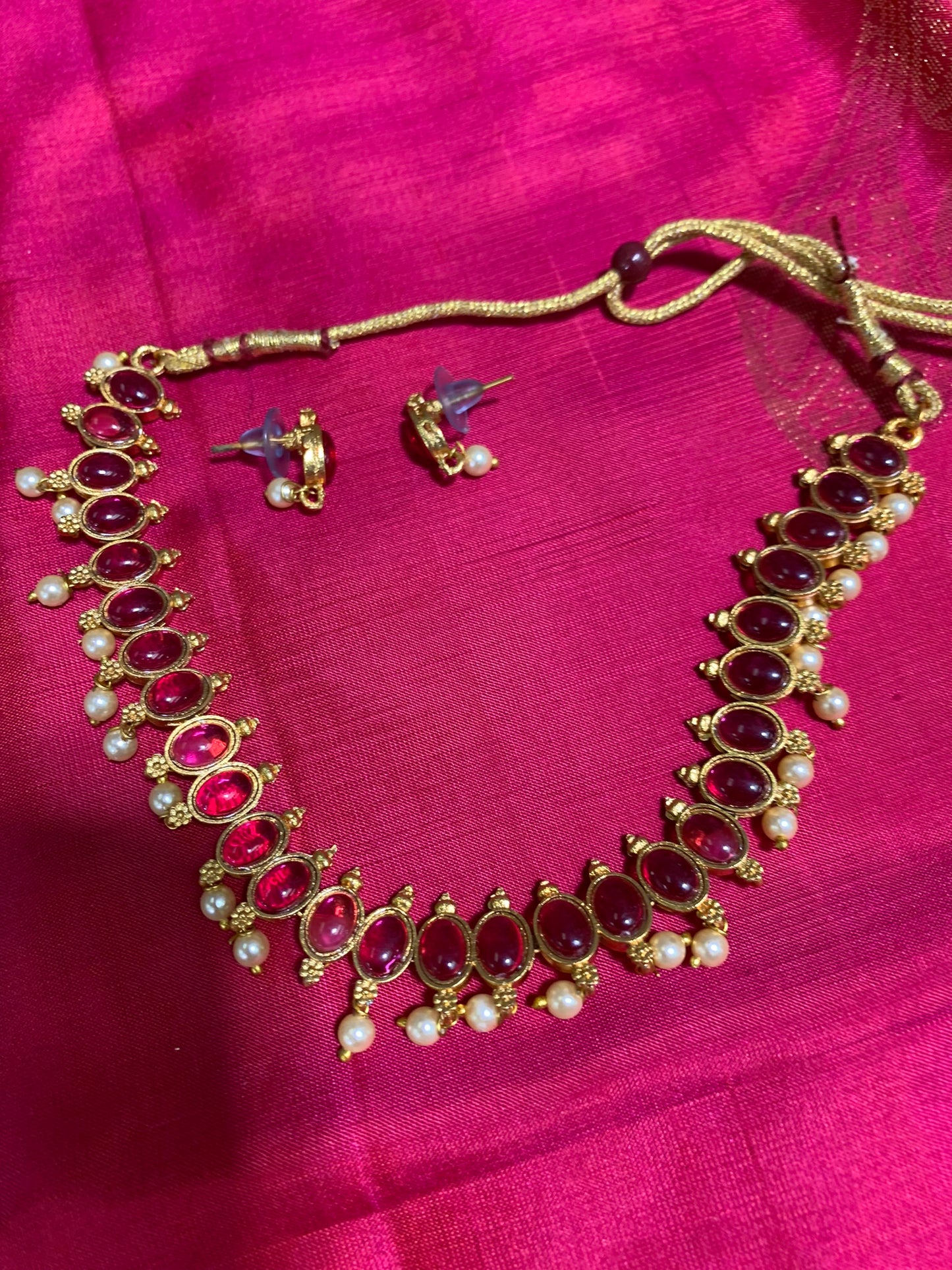 Golden necklace with pink stone